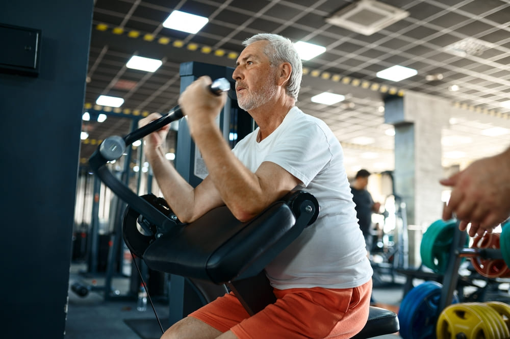 A Man Does Weight Training Exercises In A Gym